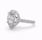 Side view of a 4 carat pear cut lab grown diamond engagement ring with a hidden halo and pavé band.