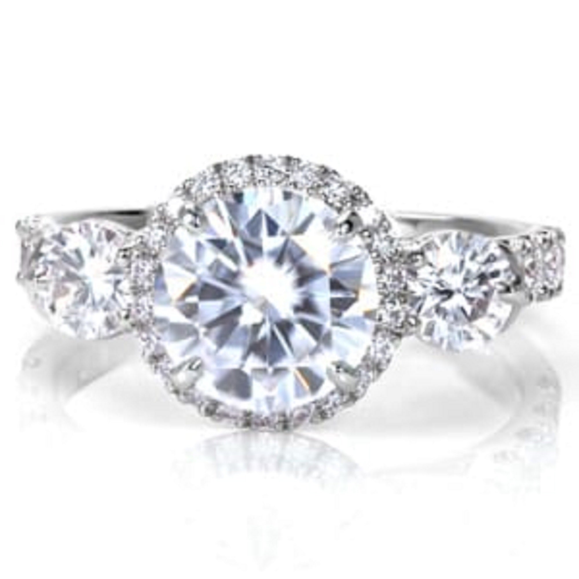 Front face angle of a 3 CT round cut lab created diamond three-stone ring with sparkling side stones.