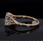 Direct profile view showing the architectural prongs and smooth gold band of a round diamond engagement ring.