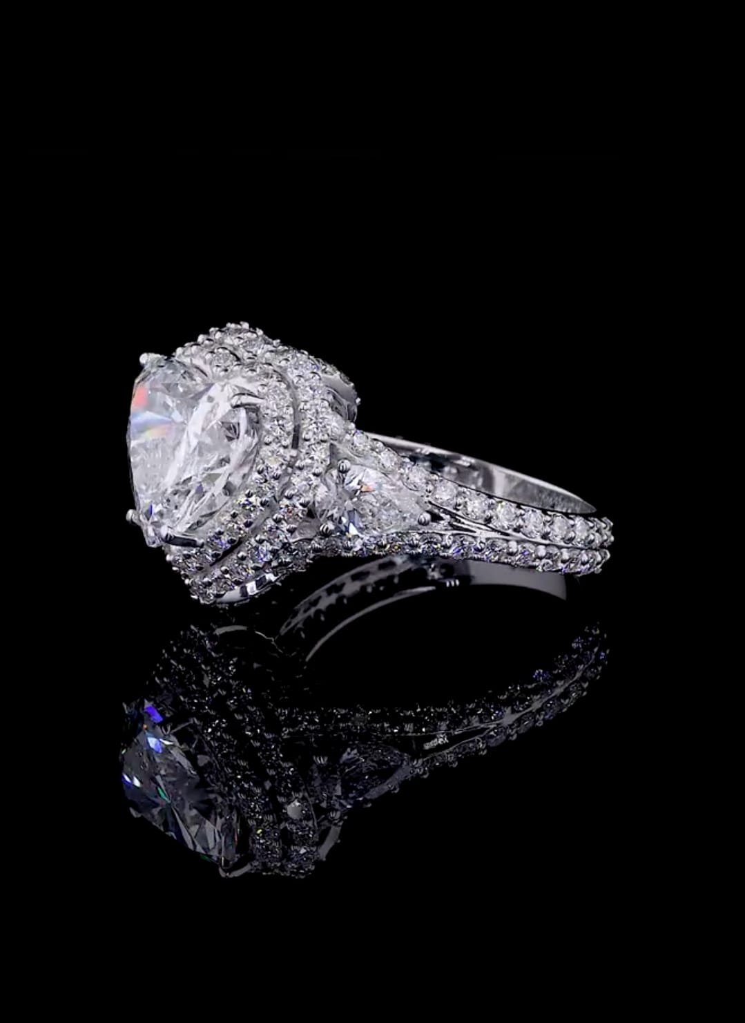 Three-quarter side view showing the pear cut side stone transitioning into the split-shank pavé band.
