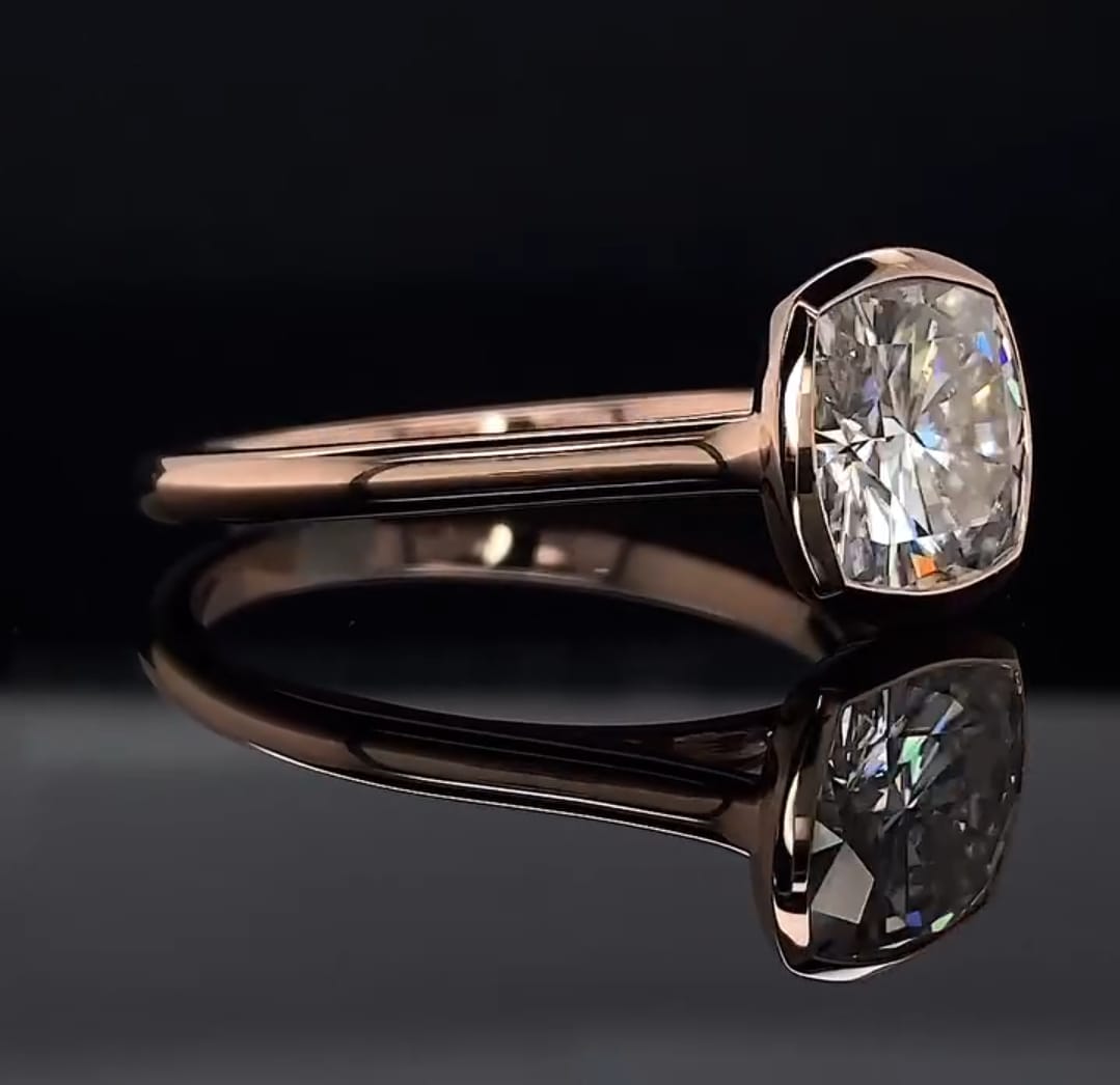 Side angled view showing the smooth gold bezel perimeter and band of a 3 carat cushion lab diamond ring.