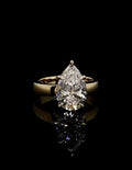 Front facing view of a 3 carat pear cut lab grown diamond engagement ring with a high-polish yellow gold band.