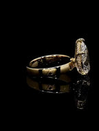 Side angle detailing the micro-pavé hidden halo basket and polished gold shank profile of a pear solitaire ring.