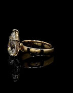 Side profile view of a 3 ct pear cut lab diamond showing the basket height, hidden halo, and wide gold band.