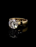 Angled front view displaying a 3 carat round brilliant lab created diamond set on a wide gold band.