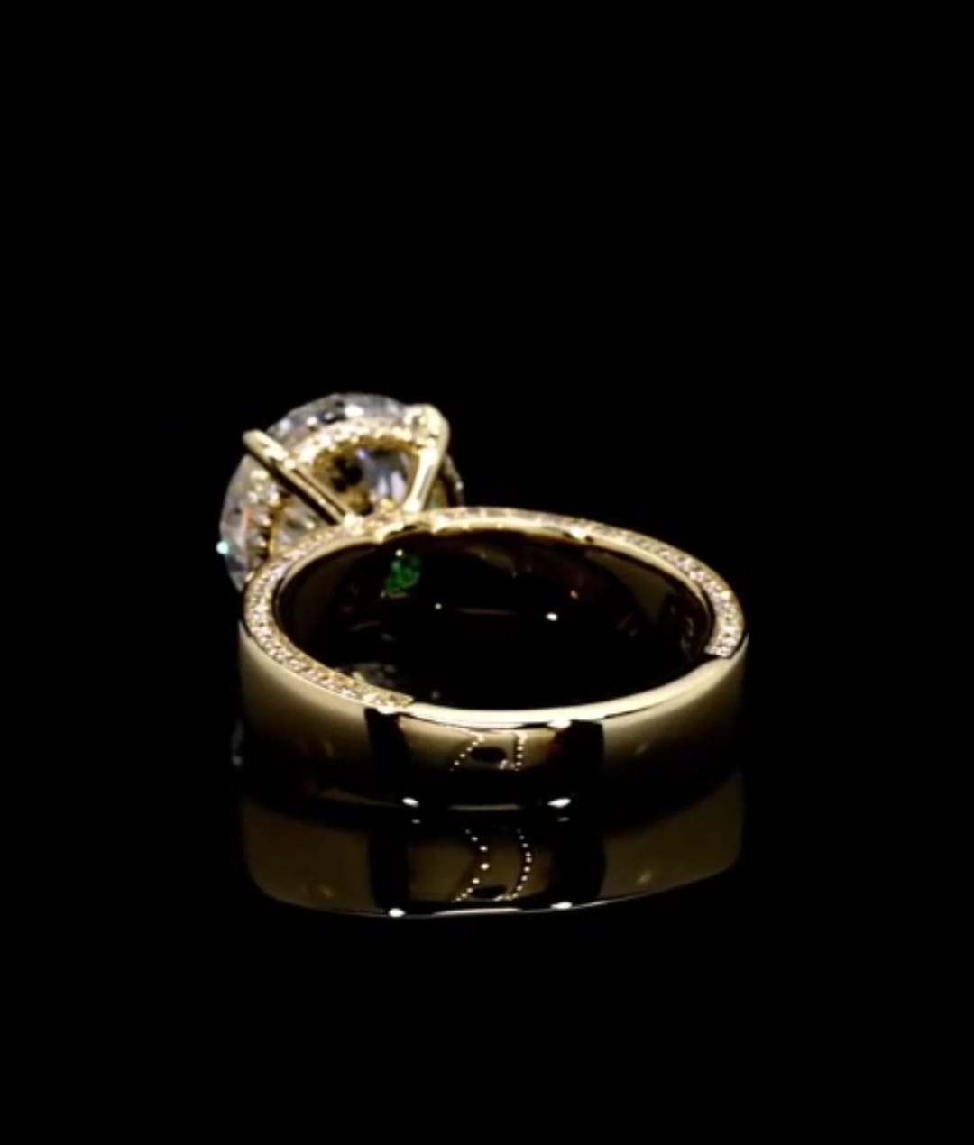 Rear angle view displaying the delicate micro pavé row along the upper edge of the solid yellow gold band.