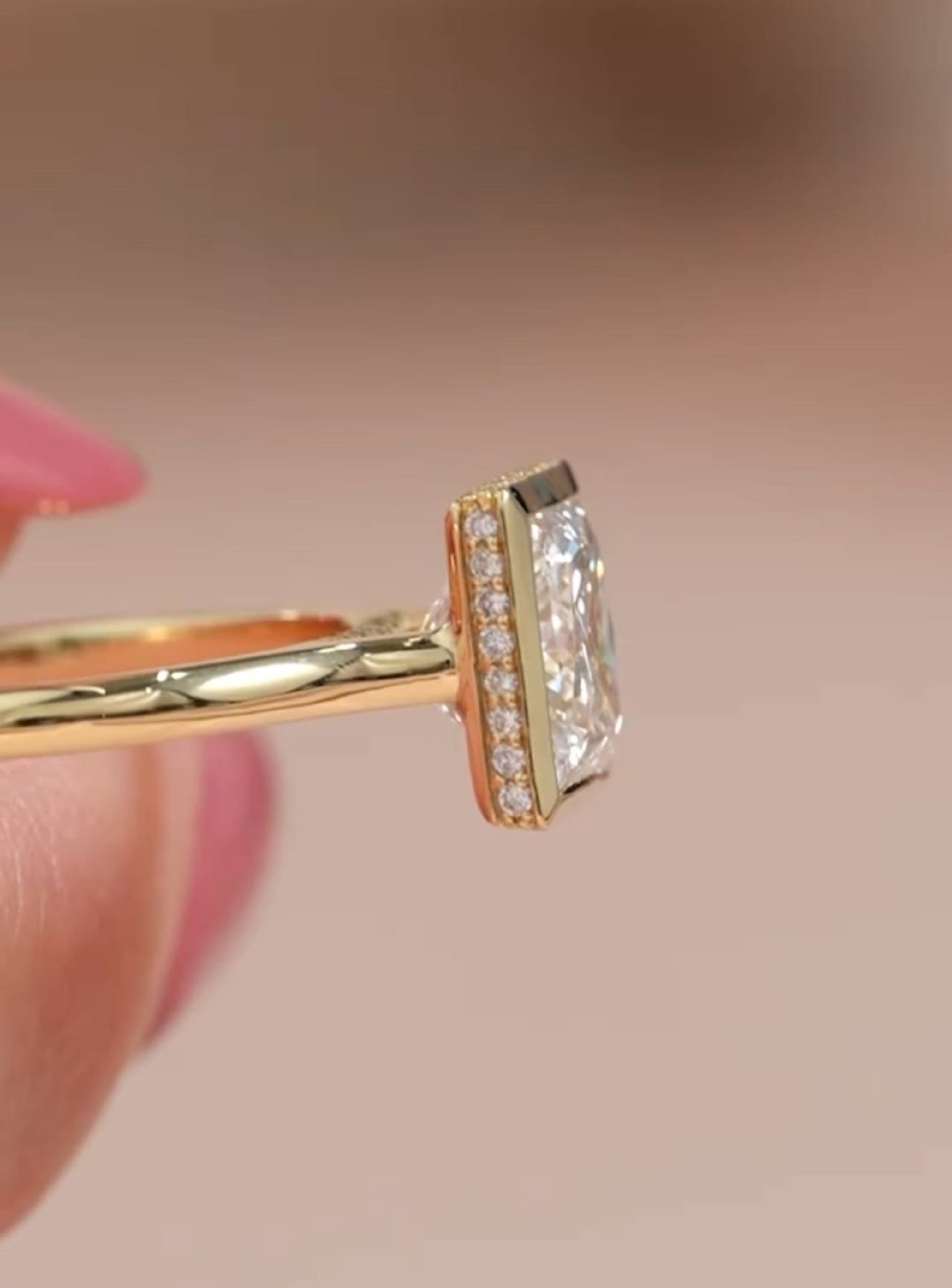 Close-up profile view of yellow gold band and pavé diamond detailing under the bezel of a princess cut ring.