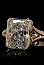 Close-up front view of a 3 carat radiant cut lab grown diamond in a yellow gold bezel setting