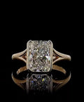 Direct front view of a 3 carat radiant cut diamond bezel ring reflecting off a polished black surface