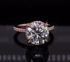 Front view of a 4 carat round cut lab grown diamond engagement ring with claw prongs and rose gold pave band