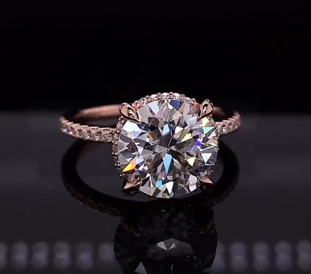 Front view of a 4 carat round cut lab grown diamond engagement ring with claw prongs and rose gold pave band