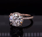 Three-quarter top angle showing a 4 carat round lab diamond ring on a black reflective surface