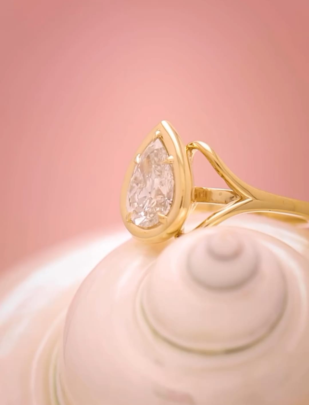 Side profile highlighting the sweeping gold split-shank curves holding a 3 carat pear cut lab diamond