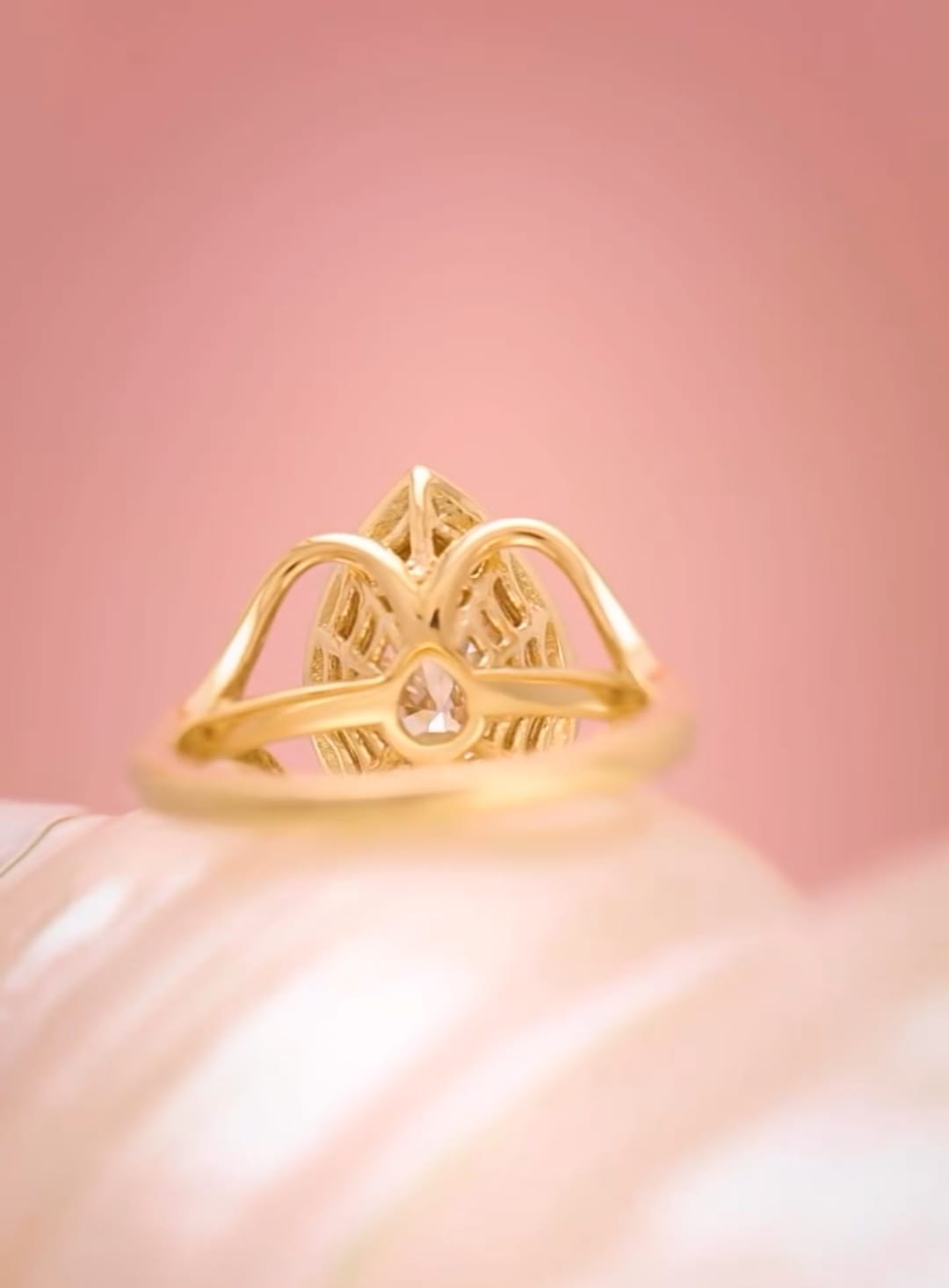 Rear profile showing the smooth gold band and intricate setting underneath the 3 carat pear cut diamond