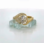 Front view of a 3 carat pear cut lab grown diamond bypass ring in yellow gold with pave diamond accents