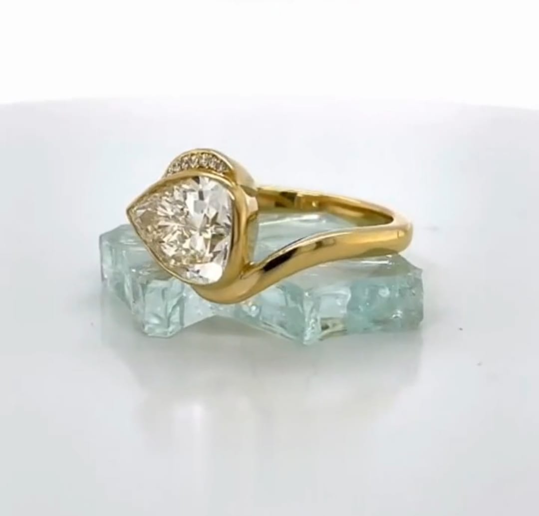 Profile angle highlighting the smooth yellow gold bypass shank and half-bezel setting