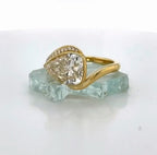 Direct shot of the 3 carat pear cut lab diamond held in a sleek gold half-bezel bypass framework