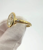 Side view of a 4 carat oval lab grown diamond ring with a milgrain bezel and hand-engraved yellow gold band