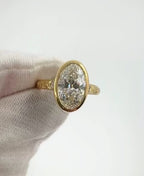 Top view showing a large 4 carat oval lab grown diamond set in a gold milgrain bezel ring