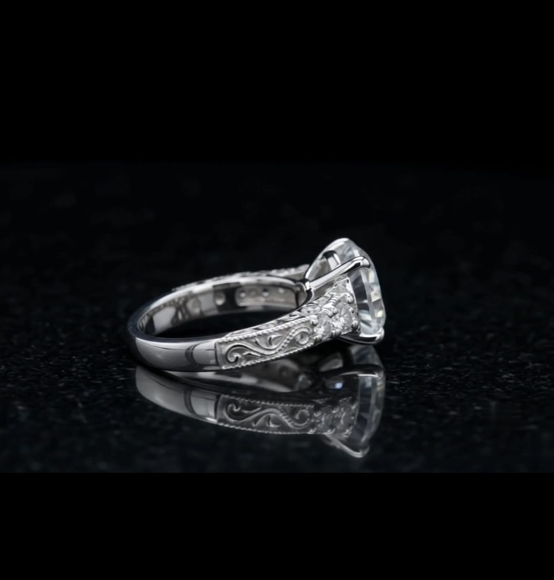 Side profile of a 3 carat round lab grown diamond engagement ring with hand-engraved filigree scrollwork in white gold
