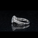 Side view of a 3 CT round lab grown diamond ring with filigree scroll engraving reflected on a black surface