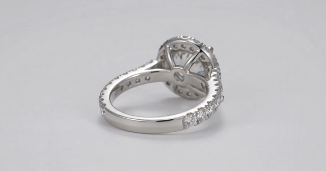 Side profile of a white gold halo engagement ring featuring a pave diamond band and solid polished bottom shank