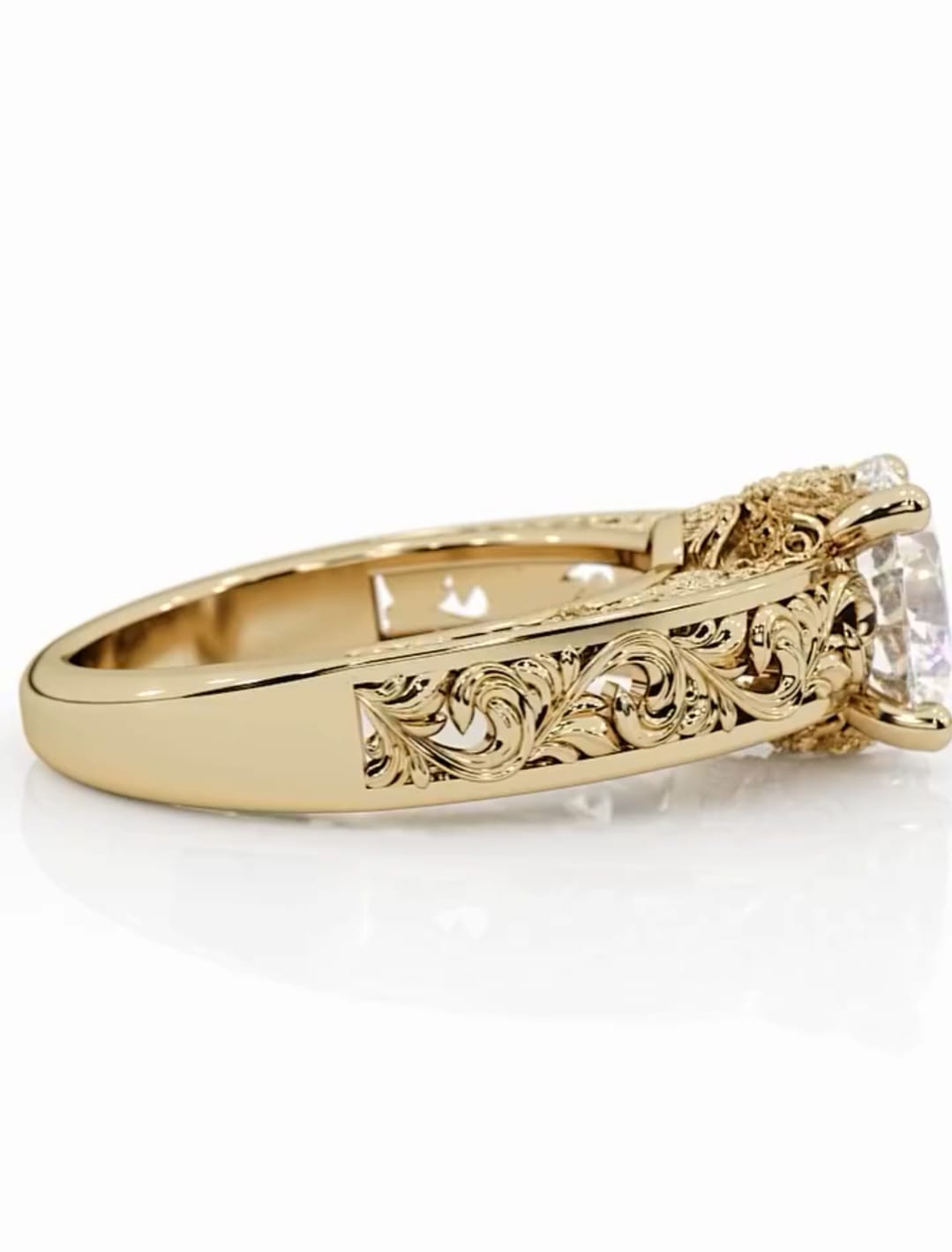 Close-up profile view of the yellow gold band highlighting the intricate, antique-style floral and scroll hand-engraving on the shank.