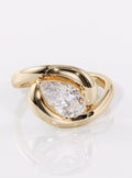 Angled top view showing the full sparkle of a 2 CT pear lab diamond framed by a chunky yellow gold setting