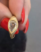 Direct top-down view of a 2 CT pear lab grown diamond encased in a milgrain-detailed yellow gold bezel