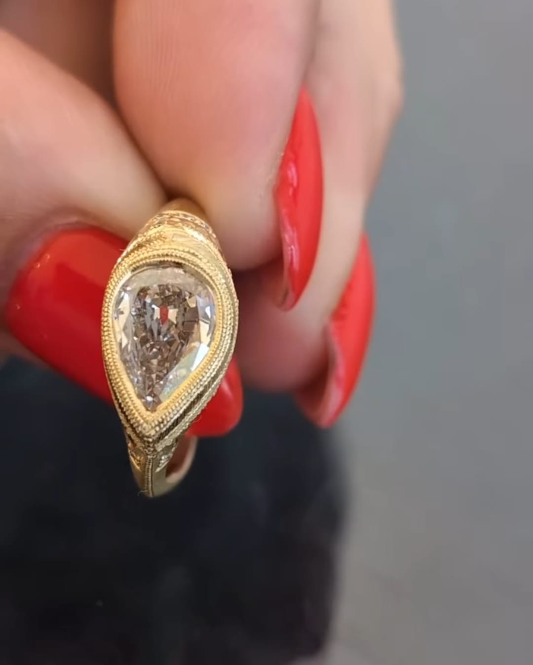 Direct top-down view of a 2 CT pear lab grown diamond encased in a milgrain-detailed yellow gold bezel