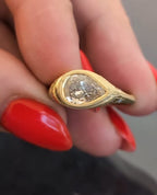 Horizontal perspective of a 2 carat pear cut diamond in a milgrain bezel setting with detailed yellow gold band