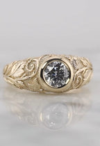 Top-down face-up view of a brilliant 2 carat round lab grown diamond set in a smooth yellow gold bezel