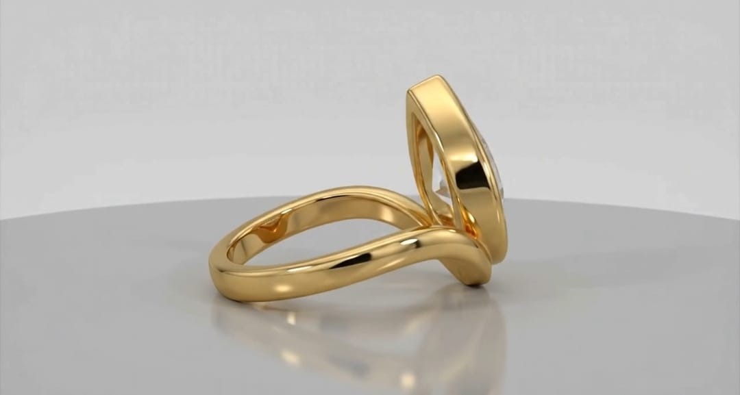 Side profile view of a 3 carat pear cut lab grown diamond bypass bezel ring in yellow gold