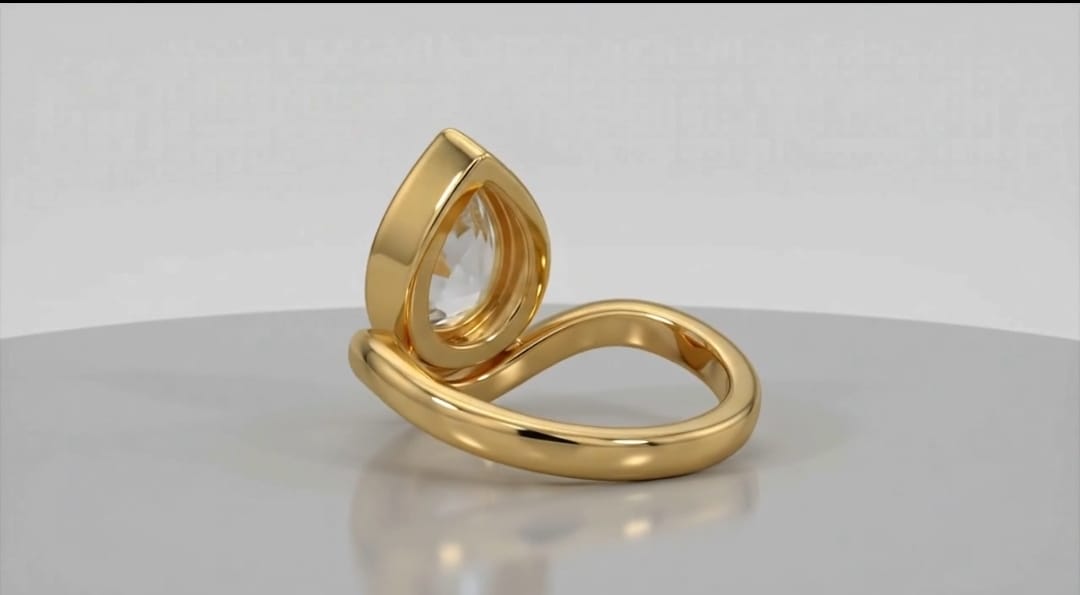 Back view of the curved yellow gold band and bezel setting of a pear lab grown diamond ring