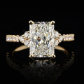 Front face view of 3 CT radiant cut lab grown diamond engagement ring with cluster side stones and pavé band in yellow gold