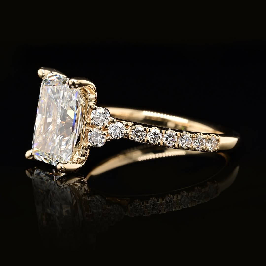 Side angle view showing 3-stone round cluster accent layout next to 3 carat radiant lab diamond
