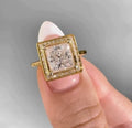 Top view showing the geometric square halo frame and slender yellow gold band of a princess lab diamond ring