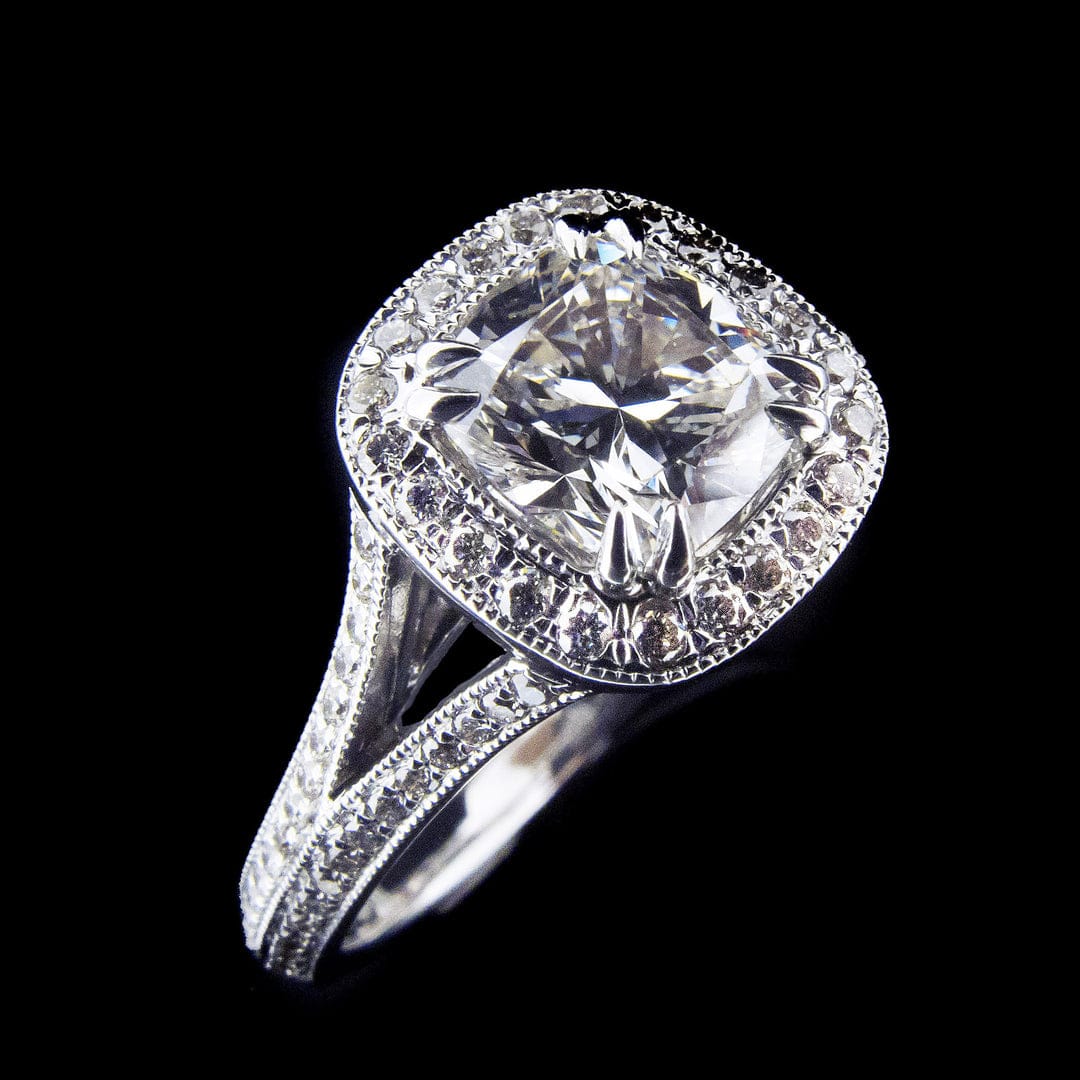 Angled view of a 3 CT cushion cut lab grown diamond engagement ring featuring a milgrain halo and split-shank pavé band in white gold