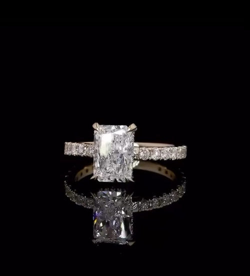 Direct front view displaying the brilliance and faceting of a 2 carat elongated radiant cut lab diamond on a yellow gold pavé band