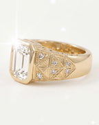 Side profile view of an art-deco style yellow gold ring, displaying the emerald cut diamond bezel and the highly detailed band featuring fan-shaped engravings and small pave-set diamonds.