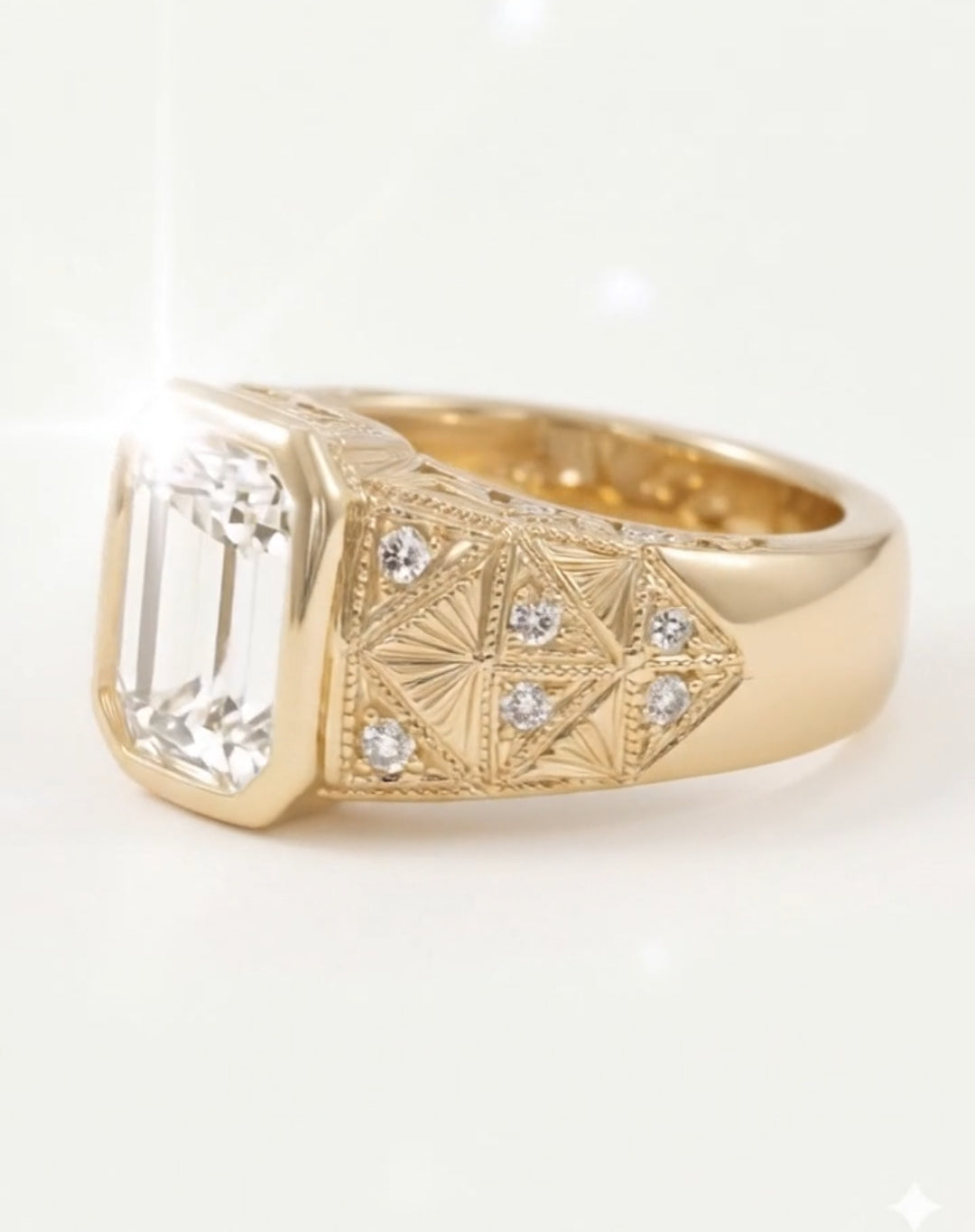 Side profile view of an art-deco style yellow gold ring, displaying the emerald cut diamond bezel and the highly detailed band featuring fan-shaped engravings and small pave-set diamonds.
