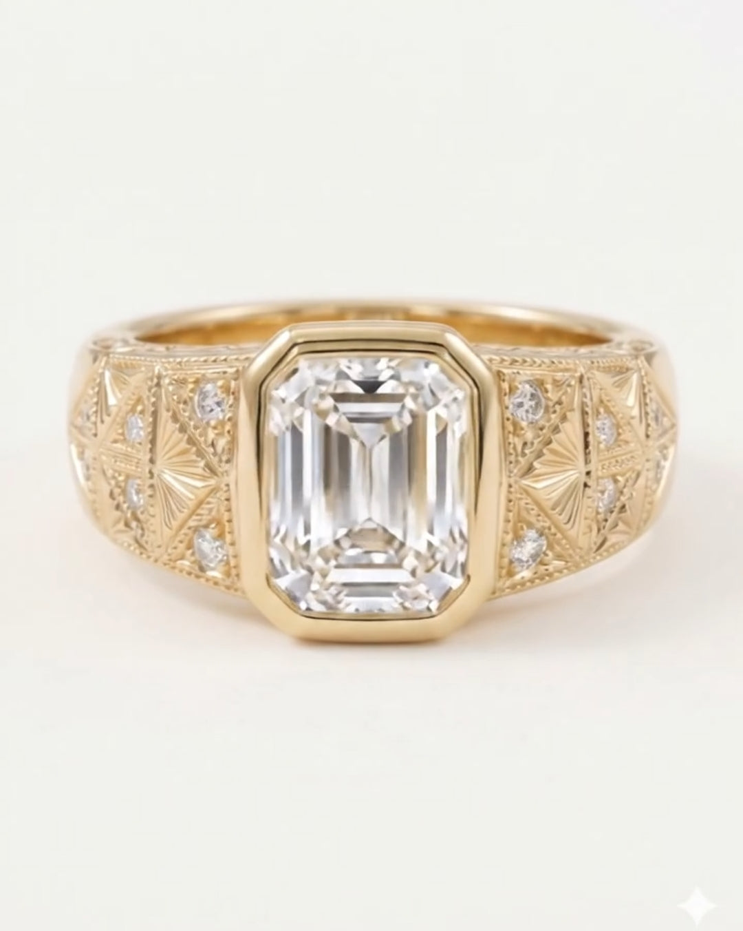 Front view of a yellow gold engagement ring featuring a large bezel-set emerald cut diamond on a wide, engraved band.