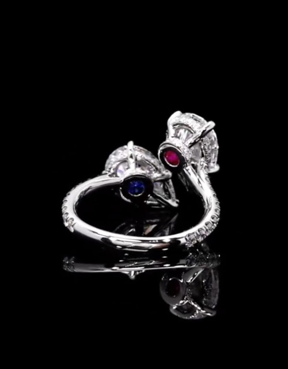 Under-gallery shot revealing the hidden ruby and sapphire gemstone accents beneath the twin pear diamond settings