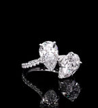 Top perspective of a 3 CTW two-stone pear cut lab diamond engagement ring on black reflective background