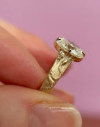 Close-up side view showing hand-engraved snake motif on a yellow gold 3 CT oval lab diamond ring