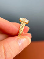 Side perspective highlighting hand-carved floral details on a satin-finished yellow gold band