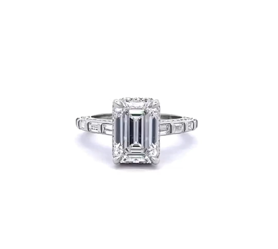 Top-down front view of a 3 CT emerald cut lab grown diamond ring with channel-set baguette band in white gold