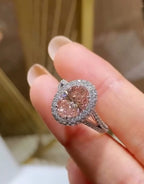 Angled view showcasing the blush tone of a 3 CT Oval Cut Pink Lab Diamond with white gold micro-pavé setting