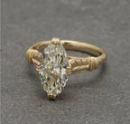 Close-up of 4ct marquise lab diamond ring displayed on linen fabric background.