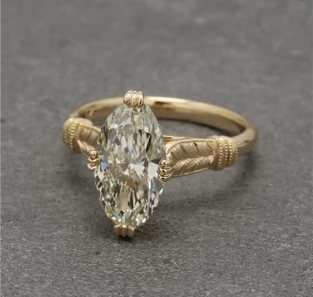 Close-up of 4ct marquise lab diamond ring displayed on linen fabric background.